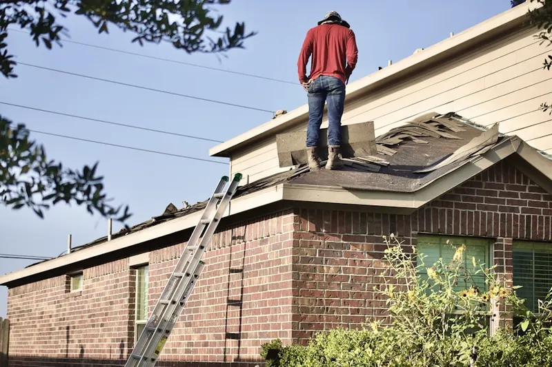 Professional roofer working on a residential roof in Joyce